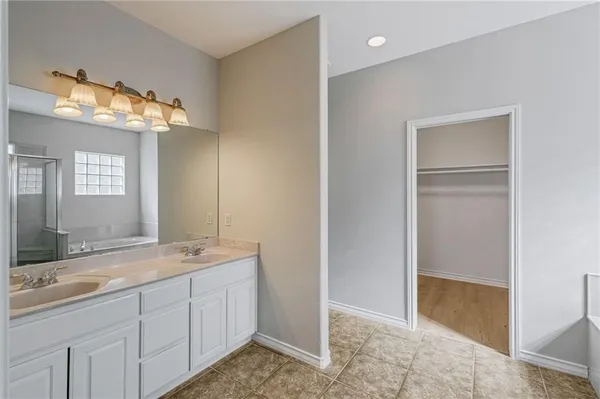 a spacious bathroom with a double vanity sink and a mirror