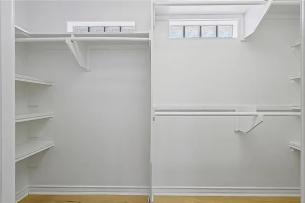a view of walk in closet with empty racks