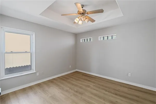 an empty room with a window and a fan