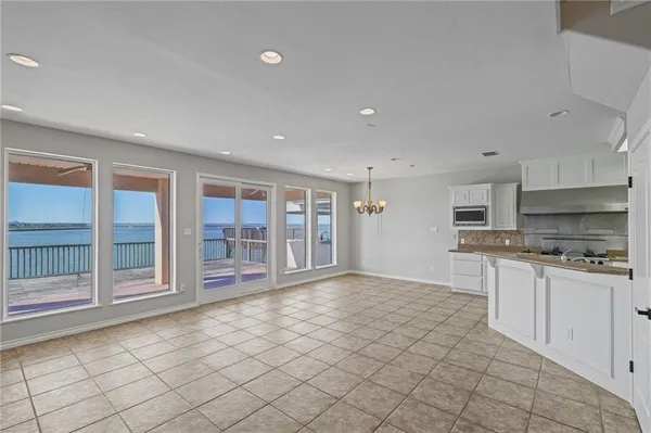 a view of an empty room with a kitchen