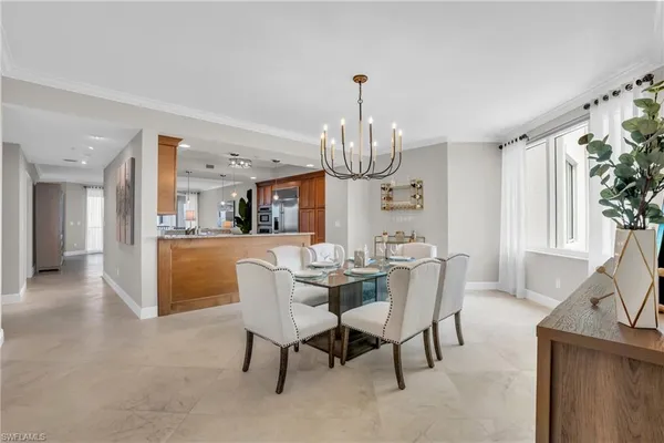 a view of a dining room with furniture a chandelier and wooden floor