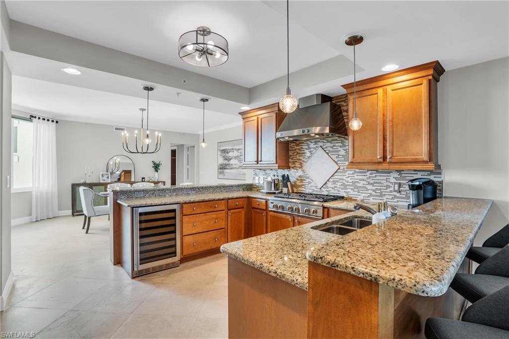 265 Indies Way, Unit 1402 Naples, FL 34110 - Photo 20 of 45 a kitchen with stainless steel appliances granite countertop a sink a stove and a wooden cabinets