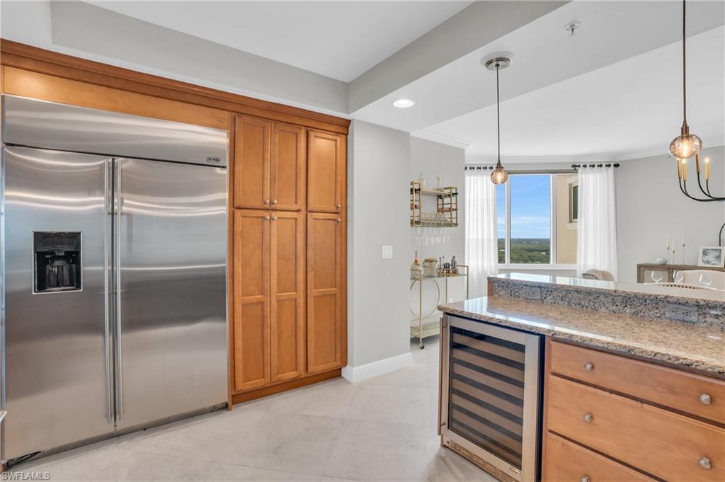 265 Indies Way, Unit 1402 Naples, FL 34110 - Photo 22 of 44 Kitchen with wine cooler, light stone counters, stainless steel built in refrigerator, and pendant lighting