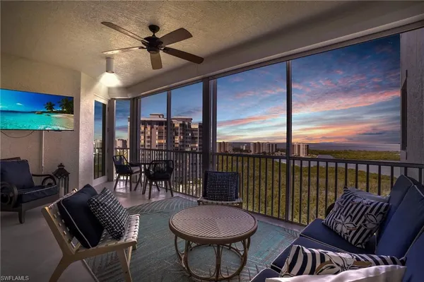 a living room with furniture a ceiling fan and a floor to ceiling window