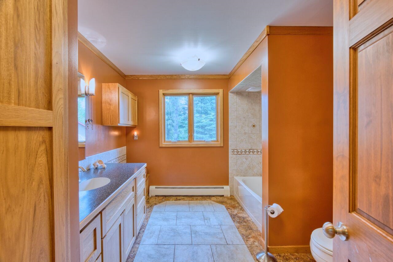 9220 Biss Road Britt, MN 55710 - Photo 20 of 50 Full bath featuring a baseboard heating unit, vanity, crown molding, toilet, and baseboards