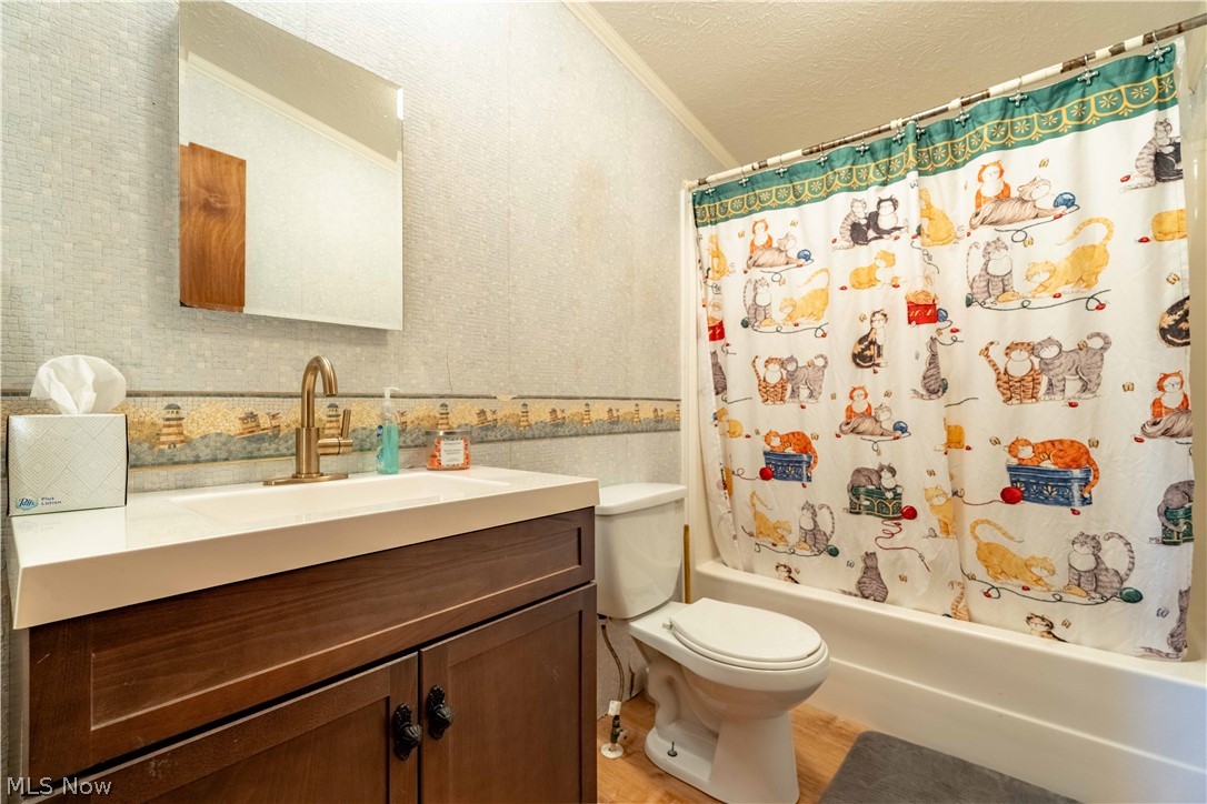 5267 Apollo Road Northeast Salineville, OH 43945 - Photo 17 of 33 Bathroom with shower / bath combo with shower curtain, wallpapered walls, vanity, ornamental molding, and a textured ceiling