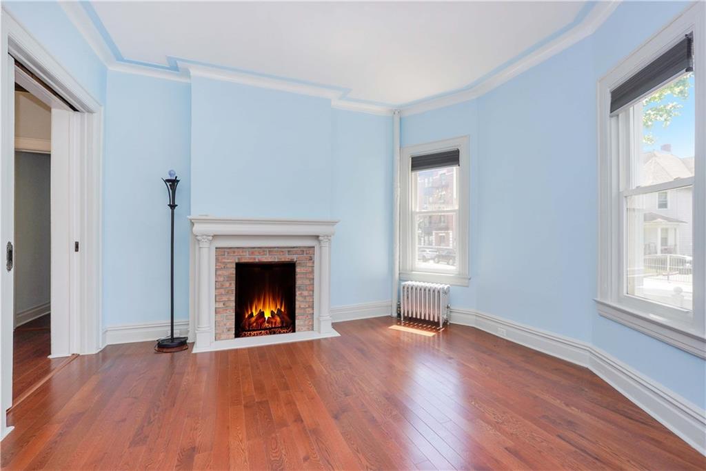 793 Westminster Road Brooklyn, NY 11230 - Photo 17 of 47 a view of an empty room with wooden floor fireplace and a window