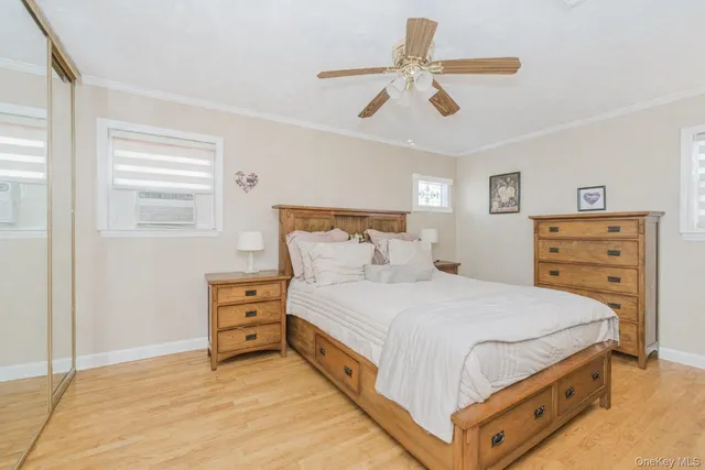 a bedroom with a bed a dresser and a chandelier
