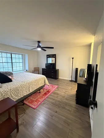 a bedroom with a bed and a ceiling fan