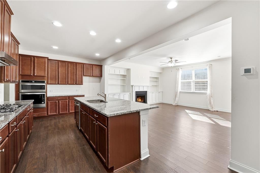 3425 Hardy Street Cumming, GA 30041 - Photo 12 of 25 a kitchen with stainless steel appliances granite countertop a stove and a refrigerator