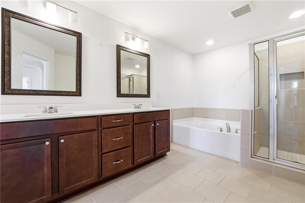 3425 Hardy Street Cumming, GA 30041 - Photo 14 of 25 a bathroom with double vanity sinks a large mirror and a bathtub