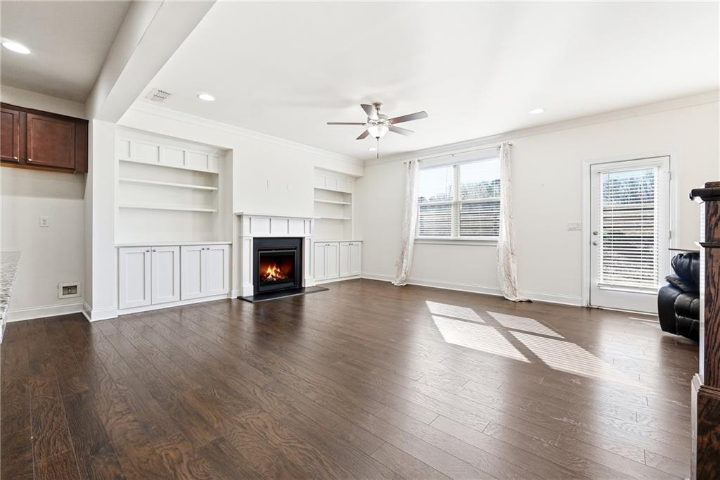 3425 Hardy Street Cumming, GA 30041 - Photo 6 of 25 an empty room with wooden floor fireplace and windows