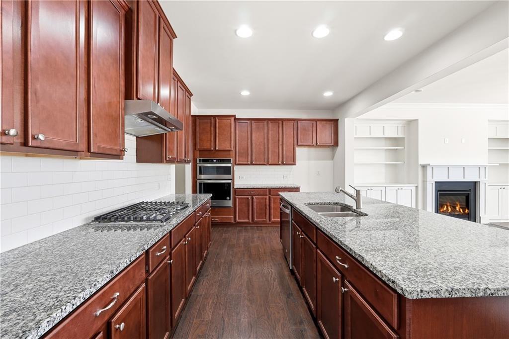 3425 Hardy Street Cumming, GA 30041 - Photo 10 of 25 a kitchen with granite countertop stainless steel appliances a sink stove and cabinets