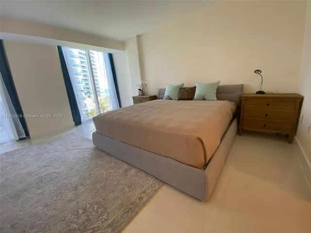 a bedroom with a bed and a large mirror