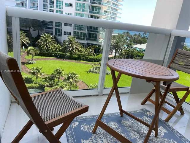 a view of a patio with table and chairs potted plants with wooden floor and fence