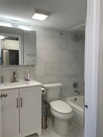 a bathroom with a toilet a sink a mirror and vanity