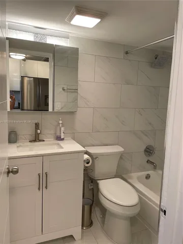 a bathroom with a toilet sink vanity and mirror