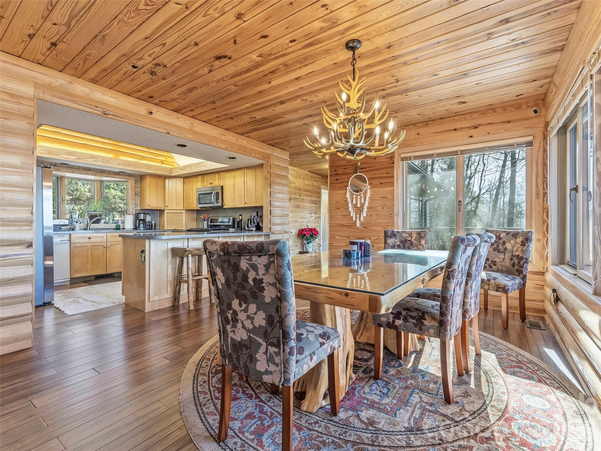 101 Ruffed Grouse Road Brevard, NC 28712 - Photo 11 of 38 a dining room with furniture a chandelier and wooden floor