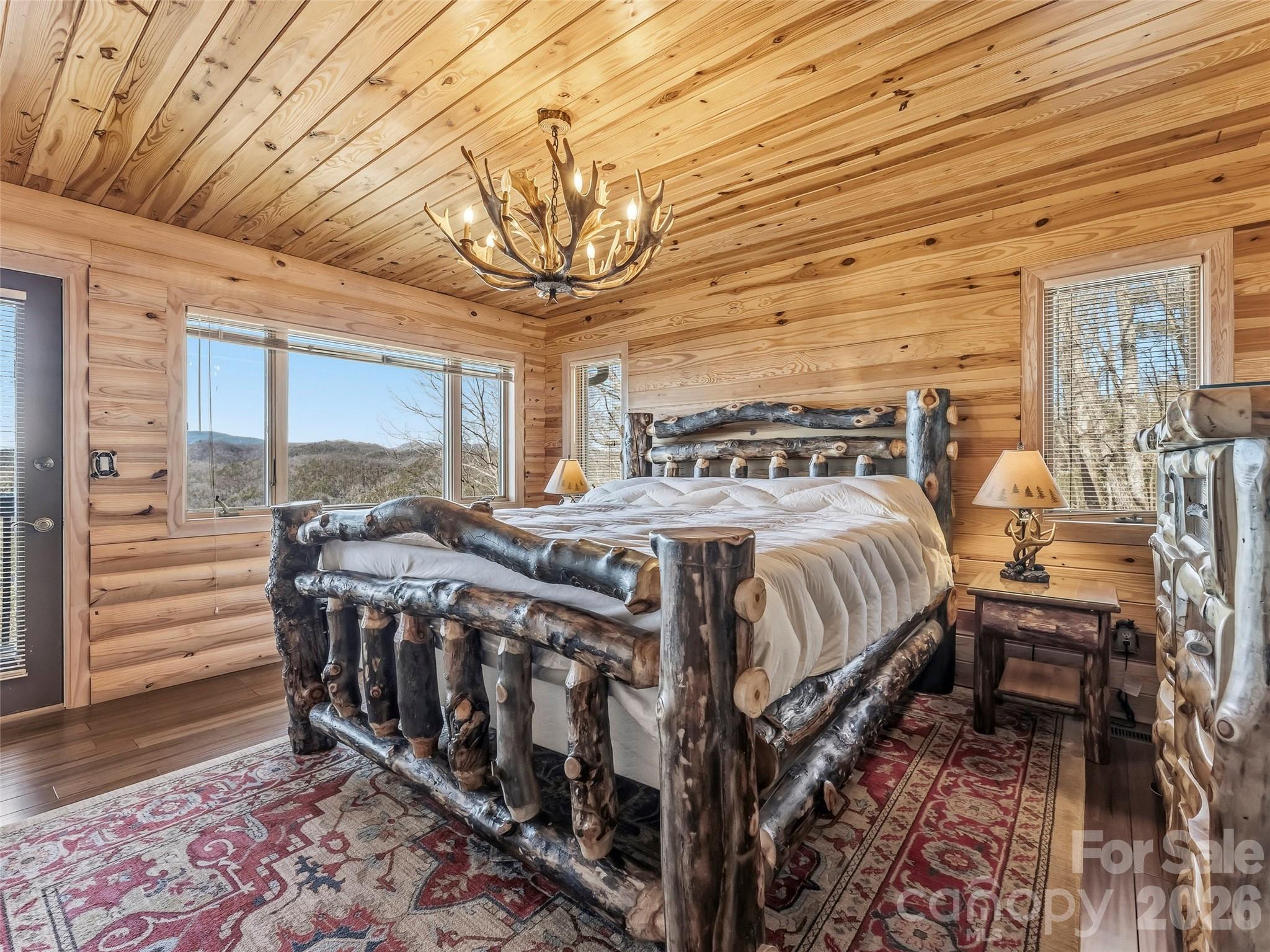 101 Ruffed Grouse Road Brevard, NC 28712 - Photo 17 of 38 a bedroom with a bed a chandelier and windows