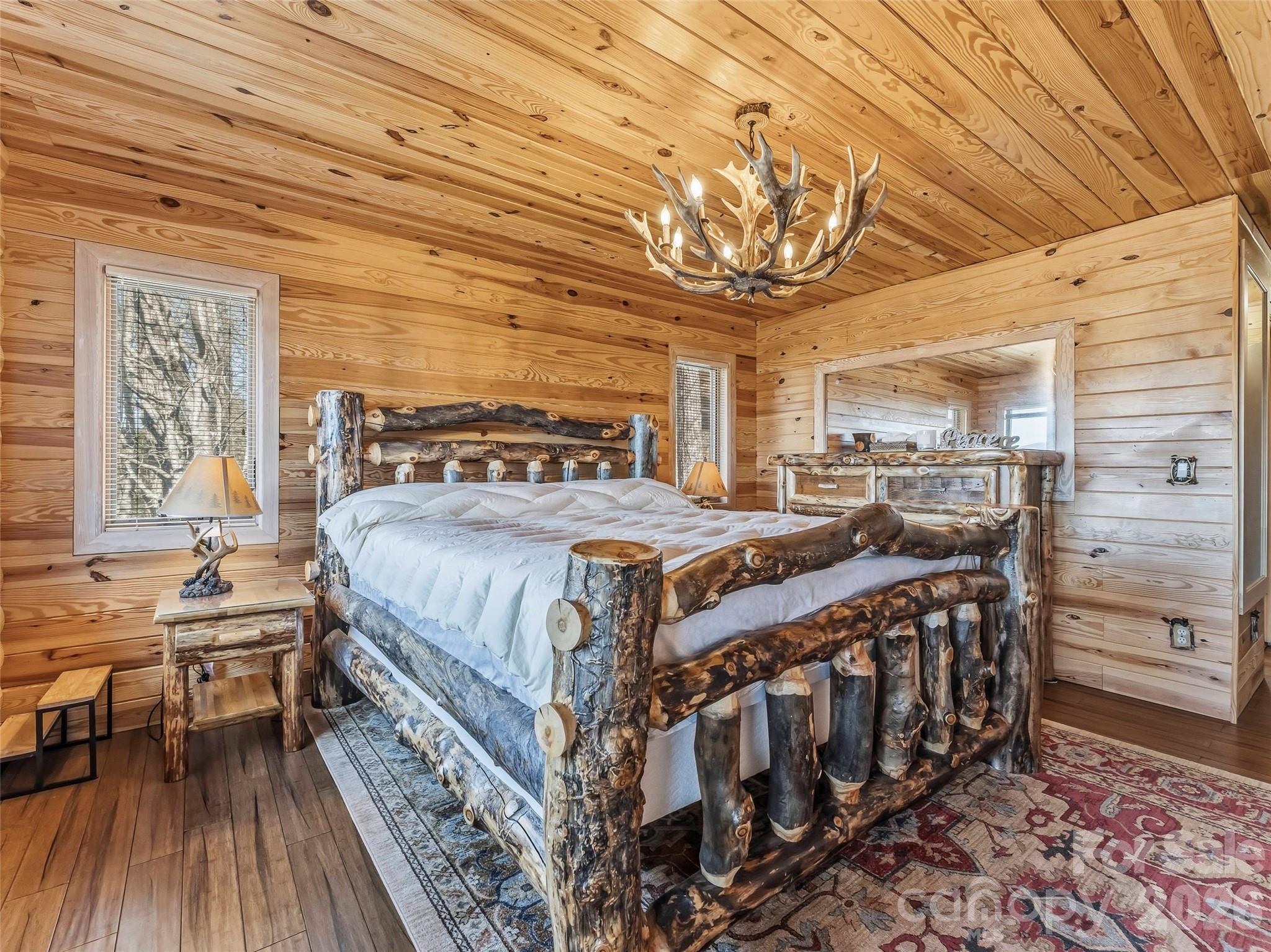 101 Ruffed Grouse Road Brevard, NC 28712 - Photo 18 of 38 a bedroom with a bed a chandelier and next to a window