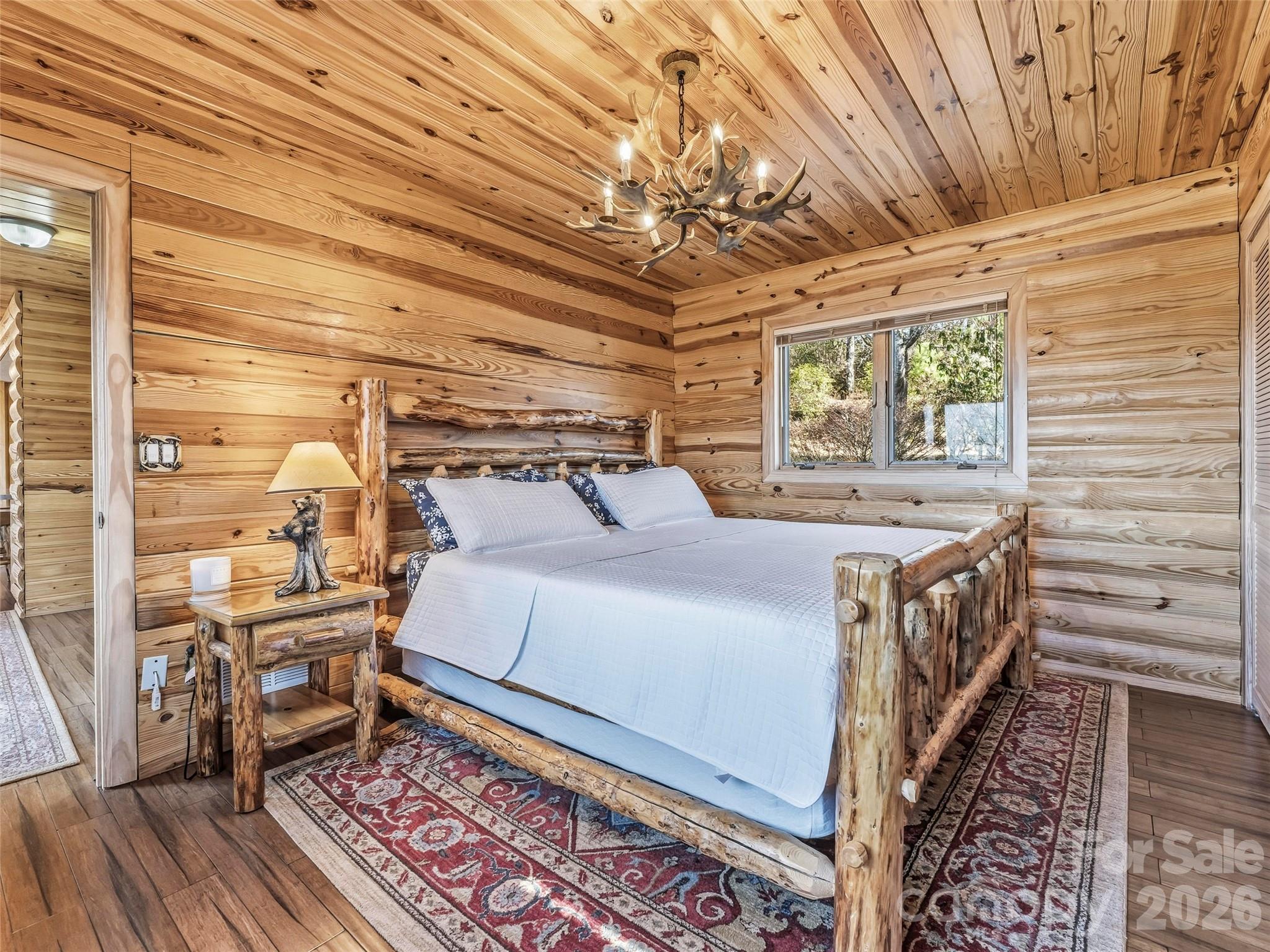 101 Ruffed Grouse Road Brevard, NC 28712 - Photo 26 of 38 a bedroom with a bed and a chandelier