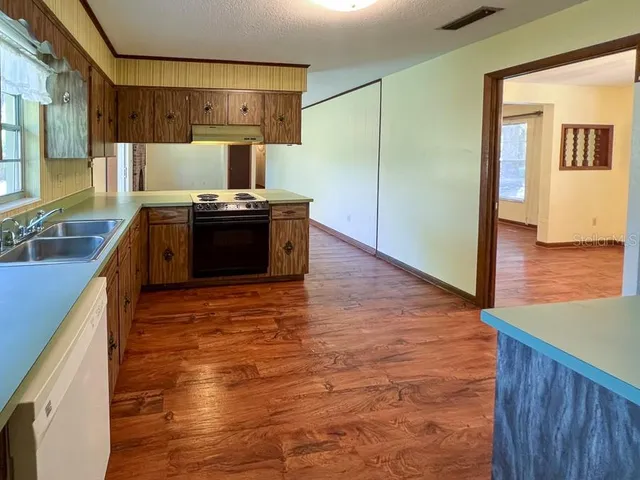 a kitchen with stainless steel appliances granite countertop a sink and a stove top oven