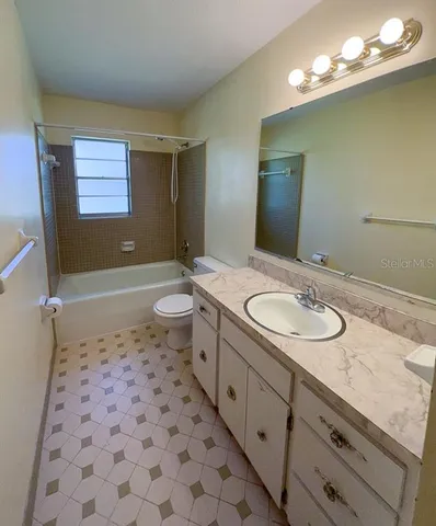 a bathroom with a sink a toilet a mirror and shower