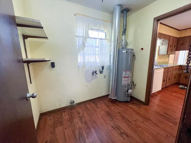 an empty room with wooden floor and a bathroom