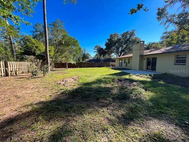 a view of a backyard with large trees