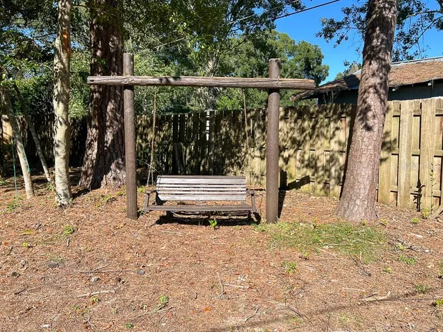 a backyard of a house with wooden floor and fence