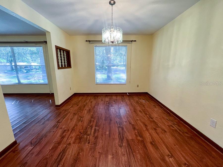 2915 Northwest 31 Terrace Gainesville, FL 32605 - Photo 6 of 33 a view of an empty room with wooden floor and a window