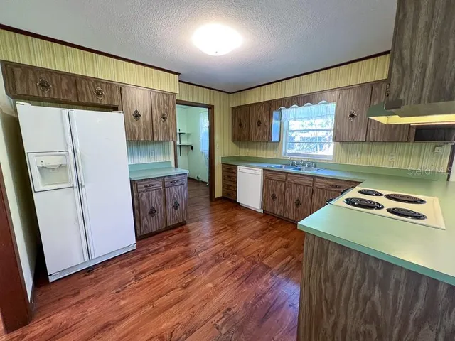 a kitchen with stainless steel appliances wooden floors and wooden cabinets
