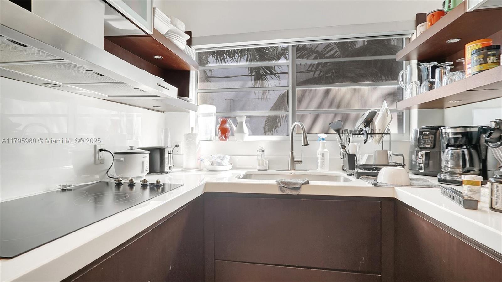 Flamingo-Lummus Miami Beach, FL 33139 - Photo 23 of 63 a kitchen with a sink dishwasher a stove and a dining table with wooden floor