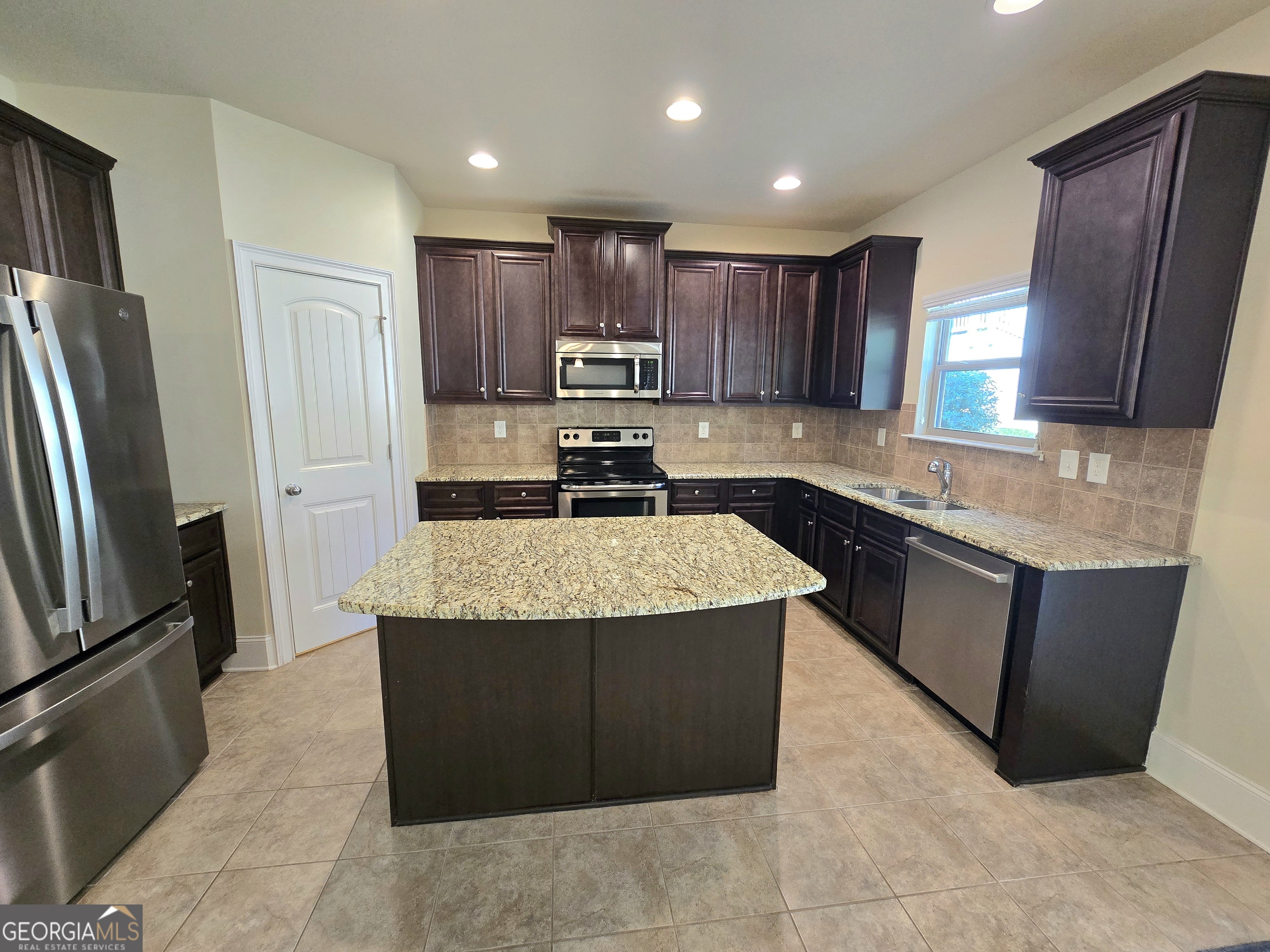 9 Ravine Drive Newnan, GA 30265 - Photo 12 of 46 a kitchen with kitchen island granite countertop wooden cabinets a refrigerator and a sink
