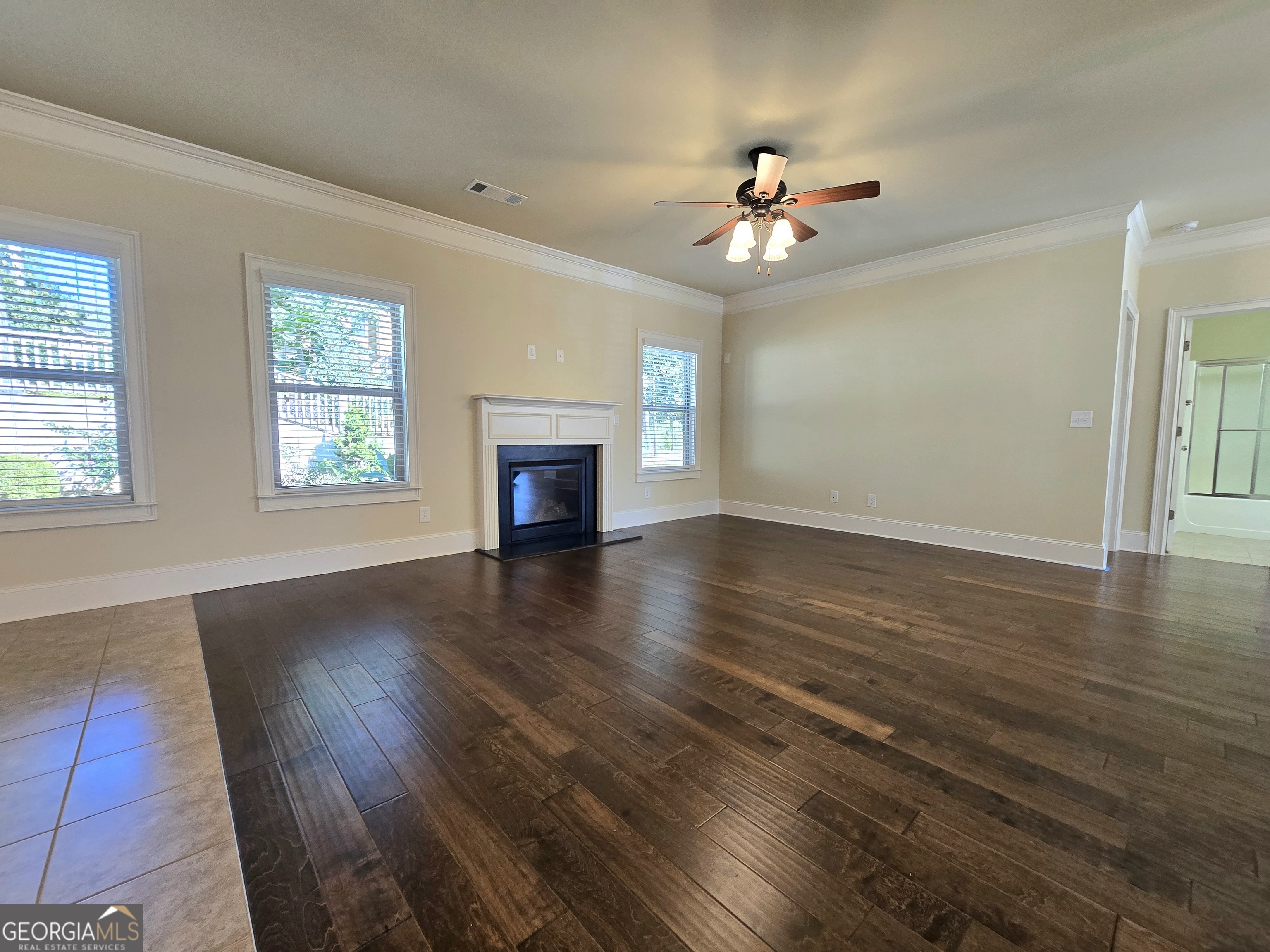 9 Ravine Drive Newnan, GA 30265 - Photo 10 of 46 an empty room with wooden floor chandelier fan and windows