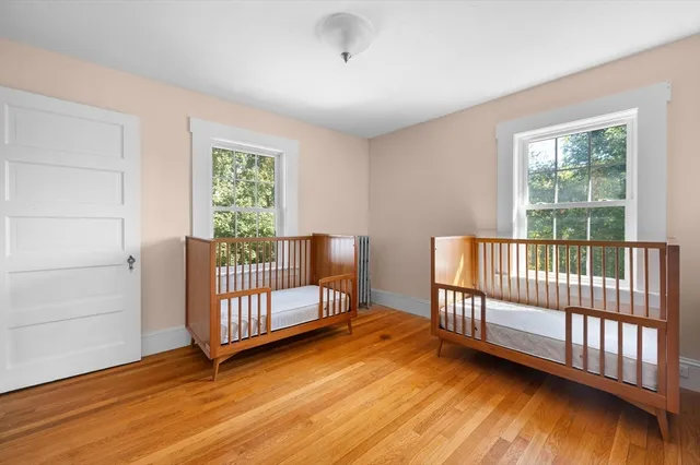 a view of a bedroom with wooden floor