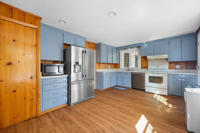 a kitchen with stainless steel appliances a refrigerator and wooden cabinets