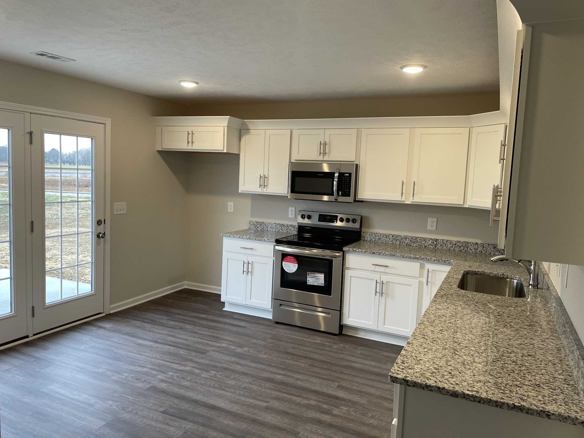 16 Frost Drive Decherd, TN 37324 - Photo 2 of 3 a kitchen with granite countertop a stove a sink and a microwave