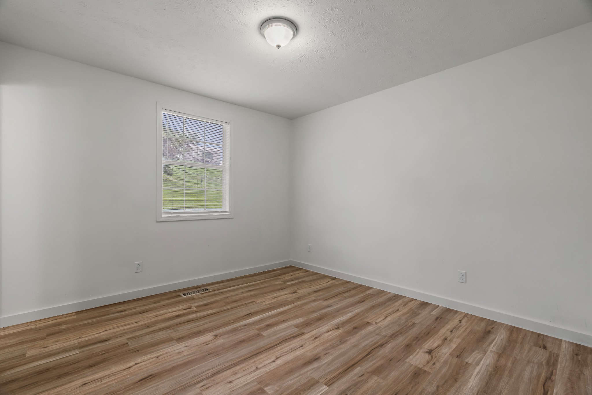 183 Cedar Street Carthage, TN 37030 - Photo 12 of 18 an empty room with wooden floor and windows