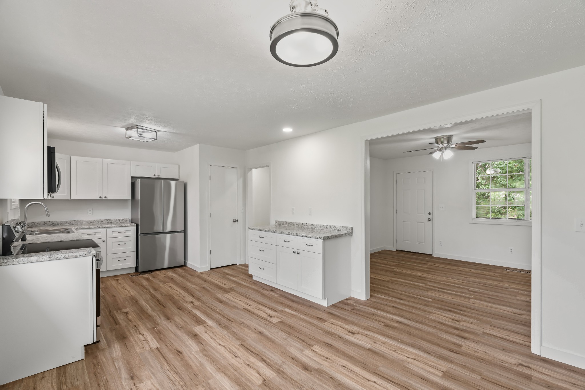 183 Cedar Street Carthage, TN 37030 - Photo 7 of 18 a kitchen with a refrigerator a stove top oven a sink and dishwasher with wooden floor