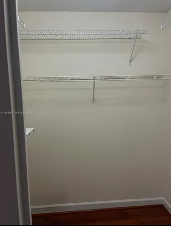 an empty room with a window and a ceiling fan