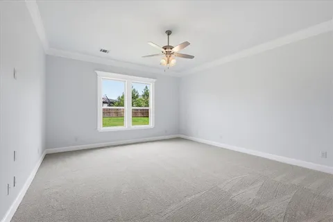 an empty room with a window and a ceiling fan
