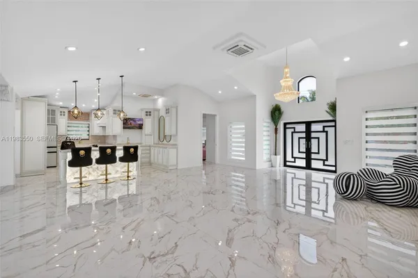 a living room with furniture a chandelier and a dining room