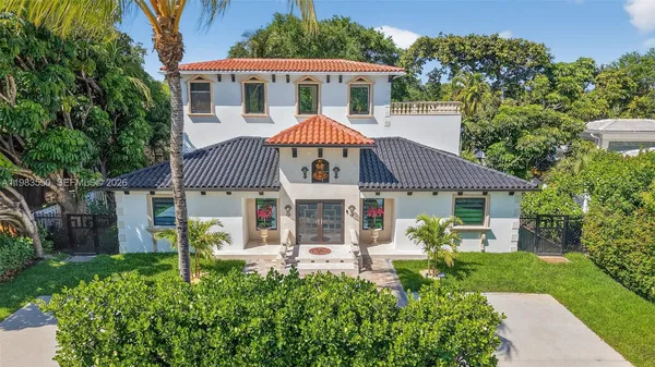 a kitchen with stainless steel appliances kitchen island granite countertop a sink a stove a dining table and chairs with wooden floor