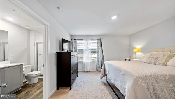 a bedroom with a bed and a refrigerator