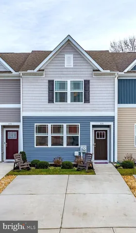a front view of a house with yard and parking