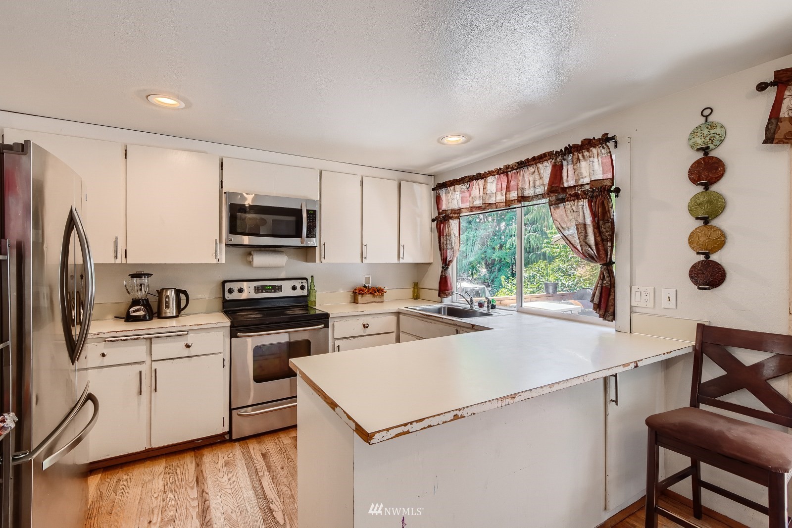 2926 165th Place Southeast Bothell, WA 98012 - Photo 3 of 11 a kitchen with a sink a stove top oven a refrigerator cabinets and dining table