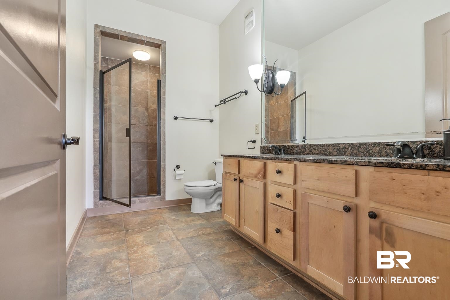 1430 Regency Road, Unit H201 Gulf Shores, AL 36542 - Photo 31 of 49 Full bath featuring double vanity, toilet, stone finish flooring, a shower stall, and baseboards