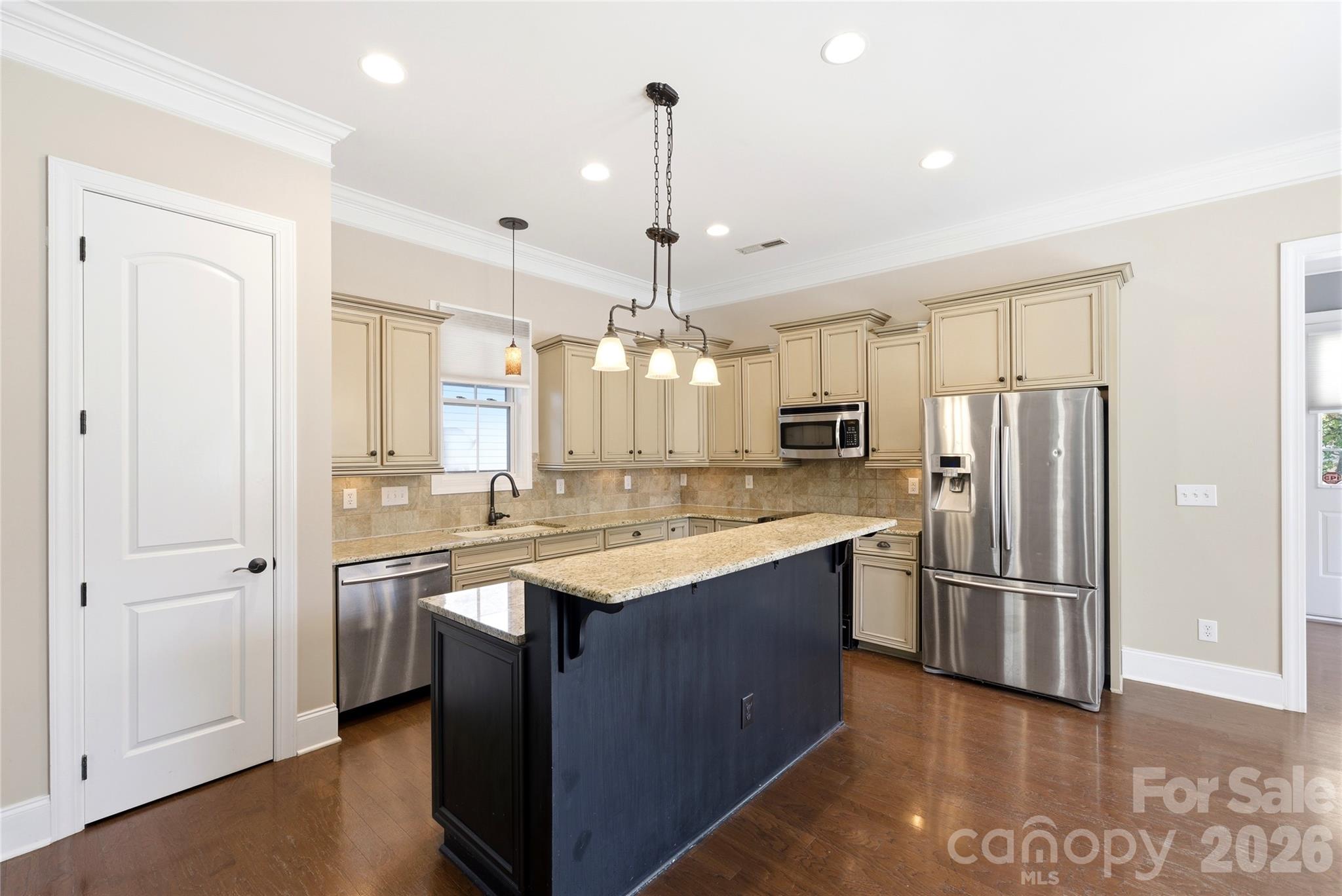10227 Sam Meeks Road Pineville, NC 28134 - Photo 6 of 27 a kitchen with stainless steel appliances granite countertop a refrigerator a sink dishwasher a oven and a dining table with wooden floor