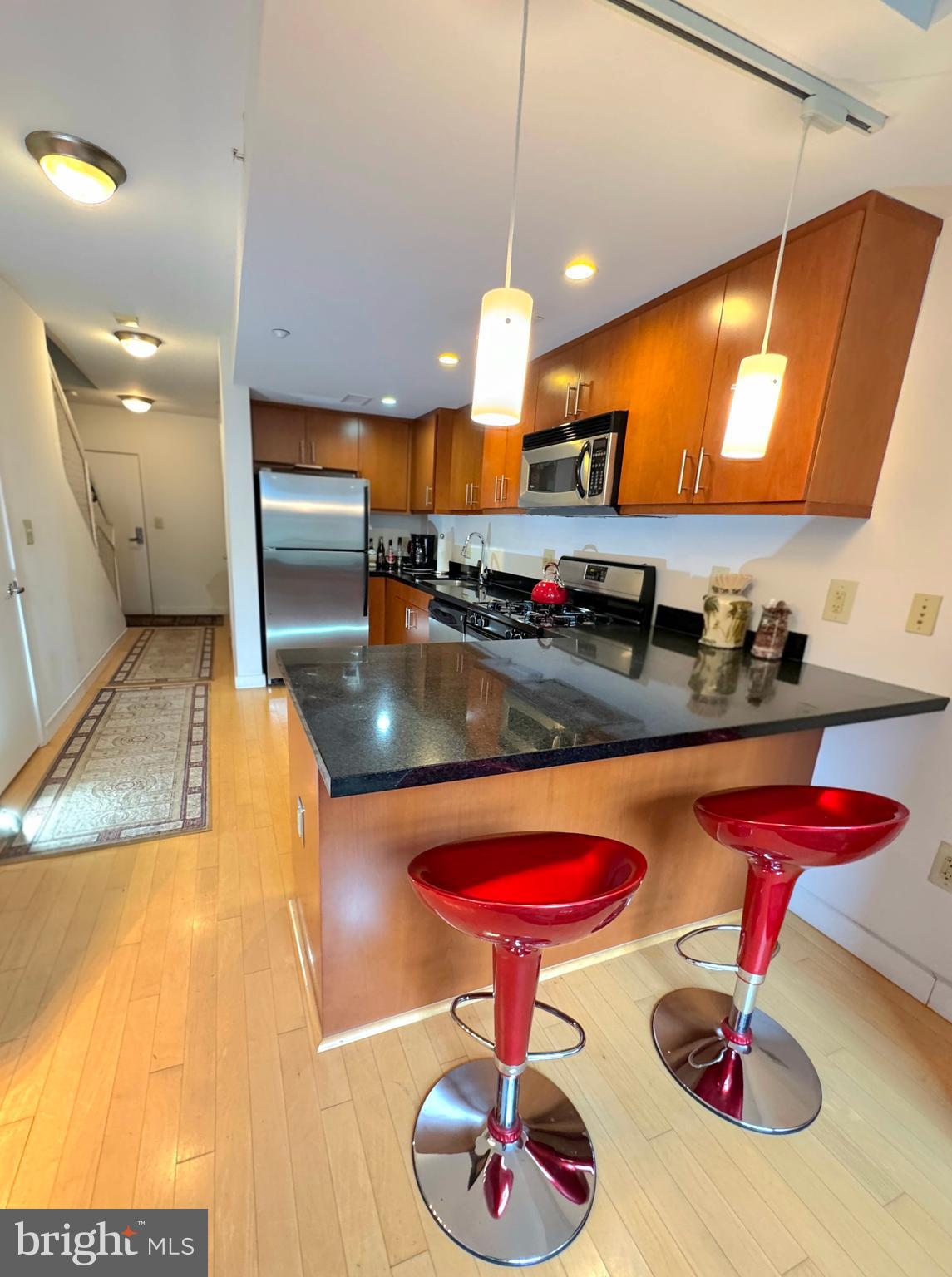 912 F Street Northwest, Unit 703 Washington, DC 20004 - Photo 14 of 52 a kitchen with stainless steel appliances granite countertop a sink a stove and a wooden floors